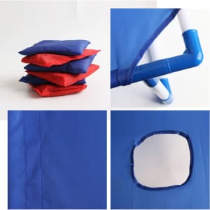 A blue portable cornhole game board with red and blue bean bags stacked beside it. It has a circular hole and piping details.