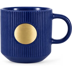 A ceramic mug in deep blue with ribbed texture and a bronze medal feature on the front.