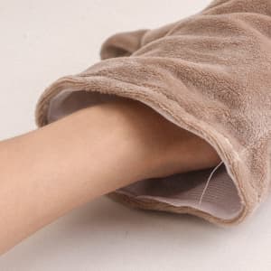 A plush, tan hand puppet with an open end, revealing a hand inside. The fabric is soft and textured.