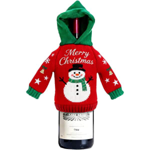 A drink bottle covered with a red and green knitted wine bottle cover featuring a snowman design.