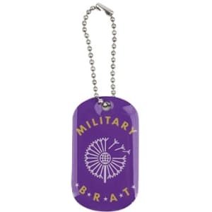 A purple dog tag with a decorative design and a silver chain. It features a logo and the text "MILITARY BRAT".