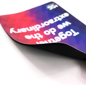 A rubber sponge mouse mat with a colourful geometric design and a logo, featuring a curved edge.