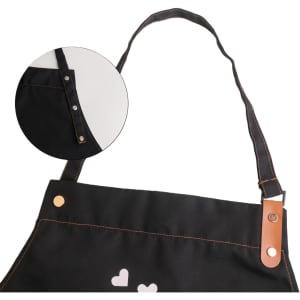A black poly-cotton canvas full bib apron featuring a neck strap and snap buttons, with a logo on the front.