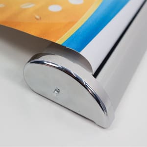 A pull-up banner with a colourful design, featuring a silver base. The image captures the banner's roll mechanism.