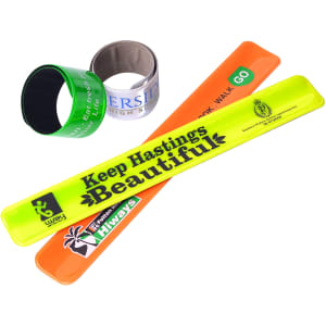 Four slap bands in various colours: neon yellow, orange, green, and black, with a logo on one.