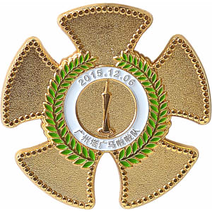 A gold cloisonné hard enamel pin shaped like a cross with a laurel wreath and a central medal.