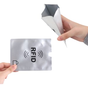 A silver RFID passport holder being held, with a hand displaying a matching RFID card.