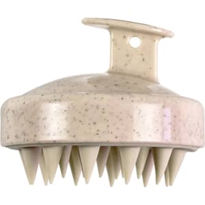 A hair scalp massager in cream colour with a smooth top and pointed bristles for massage. Features a loop for easy handling.
