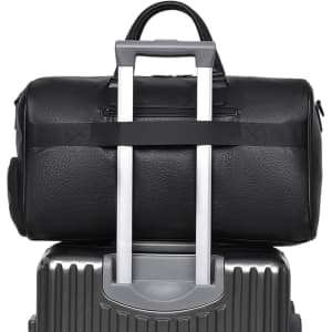 A black polyurethane duffle bag resting atop a silver suitcase, featuring a handle for easy transport.
