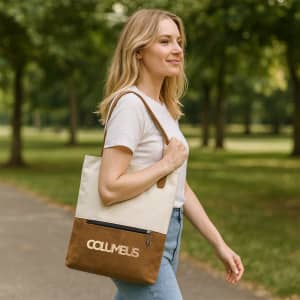 A woman walks in a park carrying a cream and brown convertible canvas backpack to tote bag with a logo.