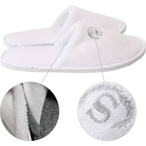 White hotel slippers with a soft texture and logo detailing, featuring a comfortable slip-on design.
