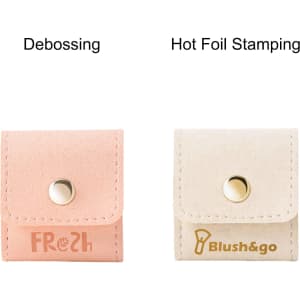 A mini synthetic leather jewellery bag in pink with debossing and a cream bag with hot foil stamping, each featuring a snap closure.