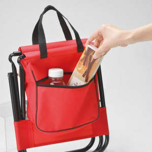 A red children's foldable camping chair with a bag featuring a pocket, perfect for storing a drink bottle and snacks.