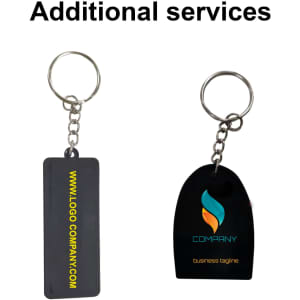 A custom-shaped PVC keyring in black with a metal ring and chain, featuring a logo. Two designs shown.