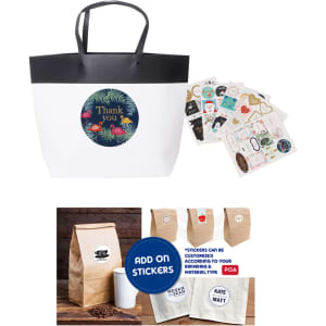 A medium black and white paper bag with black handles and assorted stickers displayed beside it.