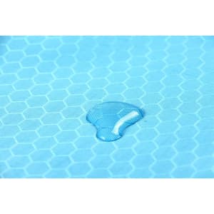 A close-up of a light blue fabric featuring a hexagonal pattern with a droplet of water on its surface.