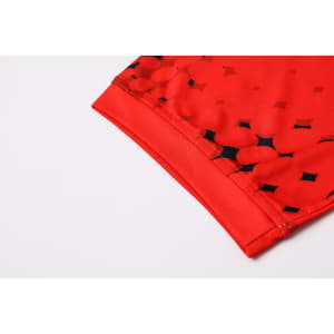 A red polyester football jersey featuring a dotted pattern and a logo on the sleeve.
