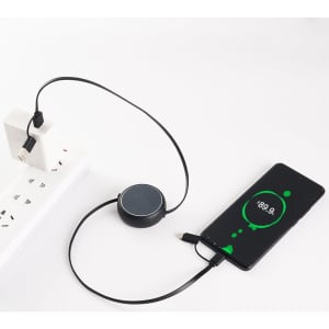 A retractable portable charging cable in black, connected to a power source and a smartphone, displaying a charging indicator.