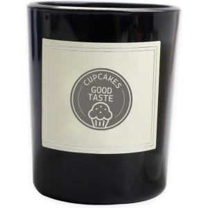 A black glass candle with a cream label featuring a circular logo and text. Ideal for home decor.