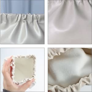 A cream-coloured, zipperless portable makeup bag with a gathered fabric design and a soft interior.