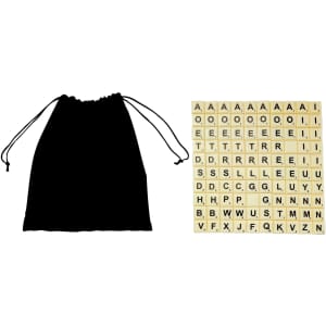 A black drawstring bag beside a collection of tan letter tiles featuring the alphabet in black lettering.