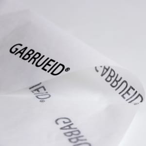 A sheet of white Kraft paper featuring a repeating black logo in an elegant font.