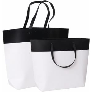 Medium black and white boutique paper bags with dual handles, featuring a solid black top and white base.