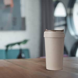 A drink bottle made from wheat straw in a neutral beige colour, featuring a lid and a simplistic design.