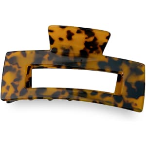 A tortoiseshell hair claw clip with a rectangular opening and a curved design, featuring a logo on the side.