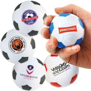 A hand squeezes a 63mm white and black football-shaped stress reliever, featuring various logos.
