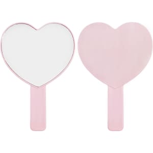 A heart-shaped handheld mirror in pink with a smooth handle, featuring a reflective surface on one side.