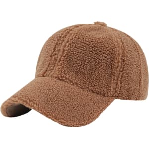 A lamb fur baseball cap in a soft brown colour, featuring a curved brim and a logo.