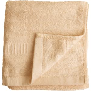 A folded bamboo fibre towel in a light beige colour, featuring a textured surface and a woven band detail.