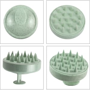 A green hair scalp massager with textured surfaces for gentle stimulation. Features a circular design and a sturdy handle.