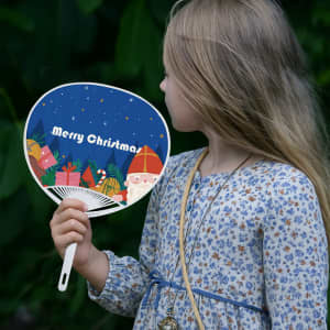 A PVC hand fan in the shape of a circle, featuring a festive Christmas design with Santa and presents.