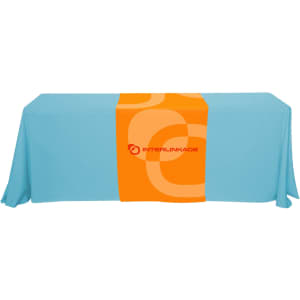 A large table runner in orange and blue, featuring a logo on the centre section.