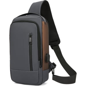 A grey and brown anti-theft sling bag with a zippered pocket and adjustable shoulder strap. It features a logo.