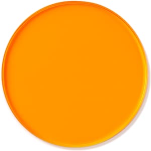 An orange custom tinted acrylic coaster with a smooth, round surface and a glossy finish.