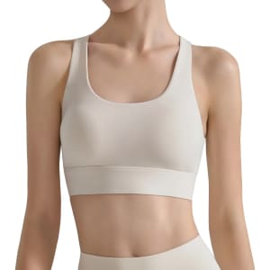 A women's cross back yoga crop bra tank in a light beige colour, featuring a sleek design and wide straps.