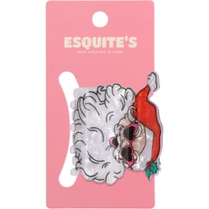 A hair claw featuring a festive design with a Santa hat and sunglasses, displayed on a pink card with a logo.