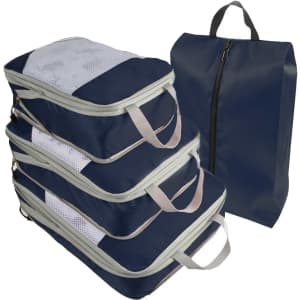 A set of navy travel packing cubes with mesh panels, featuring handles and a zippered closure.