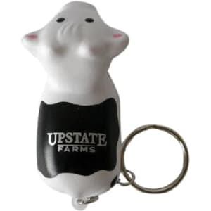 A keyring featuring a white cow stress reliever with a black section and a logo on it.