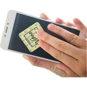 A hand cleaning a smartphone screen with a sticky microfibre cloth featuring a colourful design.