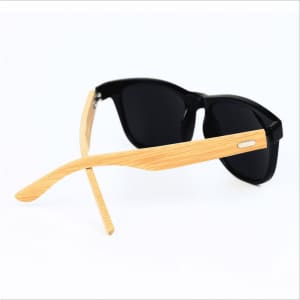 Fashion sunglasses with black lenses and bamboo arms, featuring a sleek design and a logo on the frame.