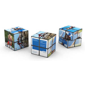 A 2x2 Rubik's Cube in multiple colours featuring various images on its faces, along with a logo.