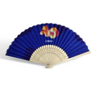 A bamboo and fabric folding fan in blue with a decorative design and a logo on the handle.