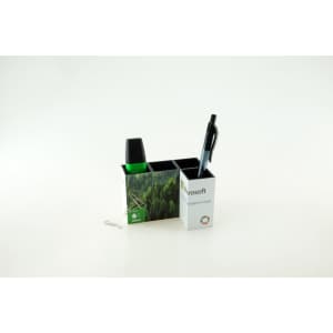 A two-compartment pen pot in black and white, holding a black pen, a green marker, and a paperclip. It features a logo.