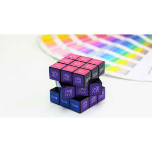 A Rubik's Cube 3x3 in black, purple, and blue featuring designs on the squares, alongside a colour palette guide.