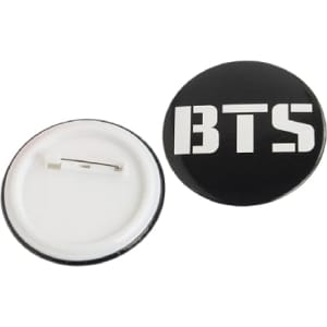 A black 56mm button badge featuring a logo on the front and a metal pin back.