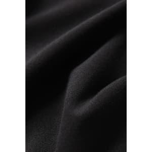 A close-up of black fabric, highlighting the texture of women's high-rise 3/4 leggings. The material is stretchy and smooth.